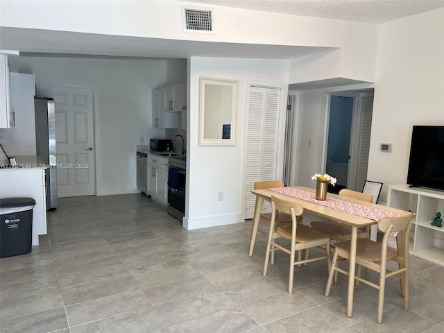 dining room with sink and a textured ceiling