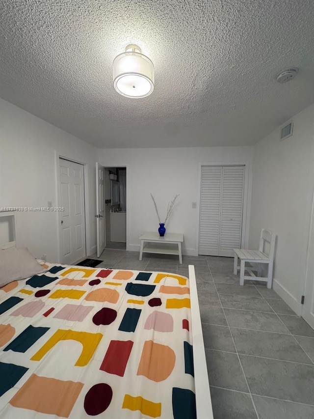 unfurnished bedroom with a textured ceiling and tile patterned flooring