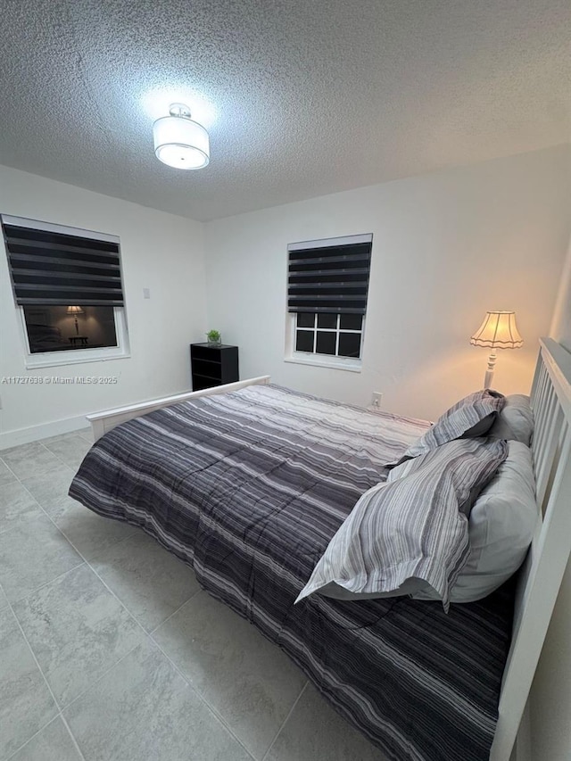 bedroom with light tile patterned floors and a textured ceiling