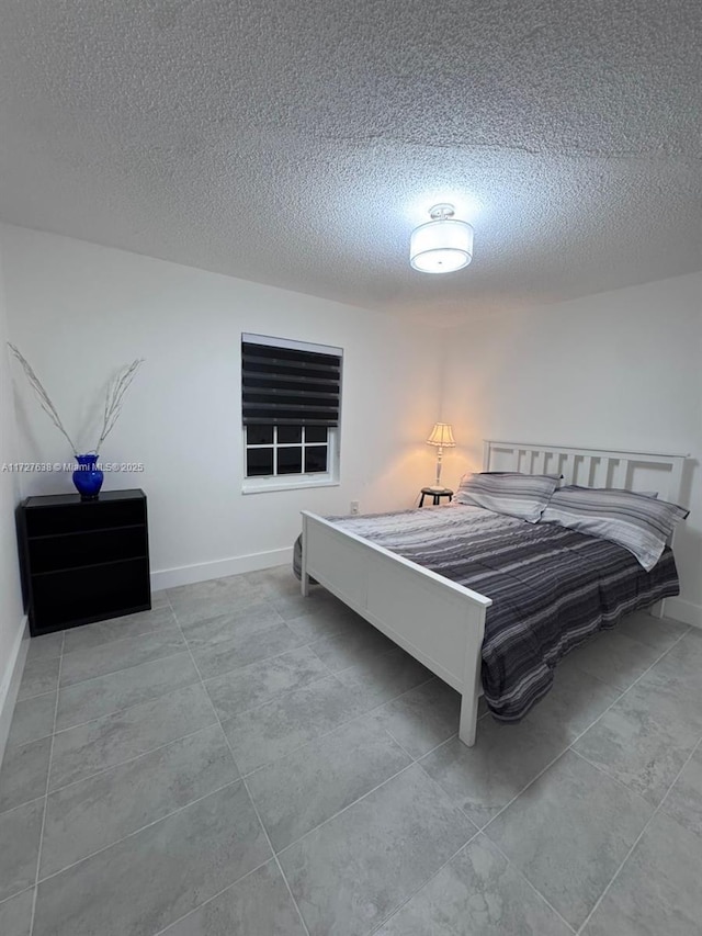 bedroom featuring light tile patterned floors and a textured ceiling