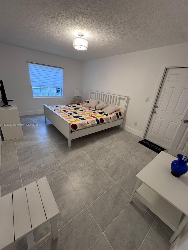 unfurnished bedroom with a textured ceiling and light tile patterned flooring