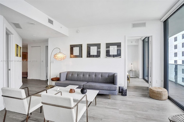 living room with floor to ceiling windows and light hardwood / wood-style flooring