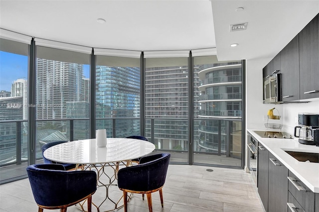 dining area featuring floor to ceiling windows and sink