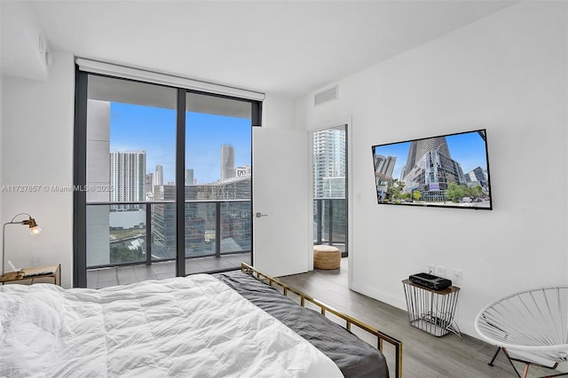 bedroom featuring light wood-type flooring and expansive windows