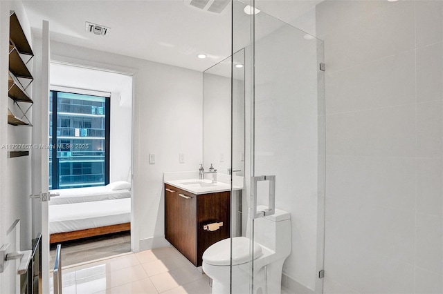 bathroom with tile patterned floors, toilet, vanity, and walk in shower