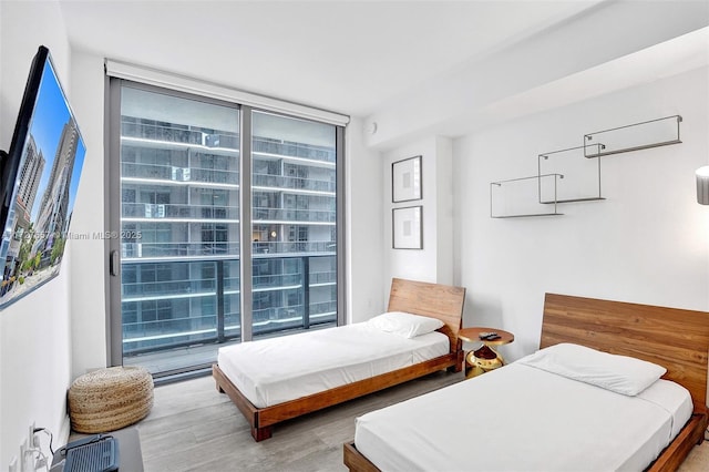 bedroom featuring floor to ceiling windows and hardwood / wood-style floors