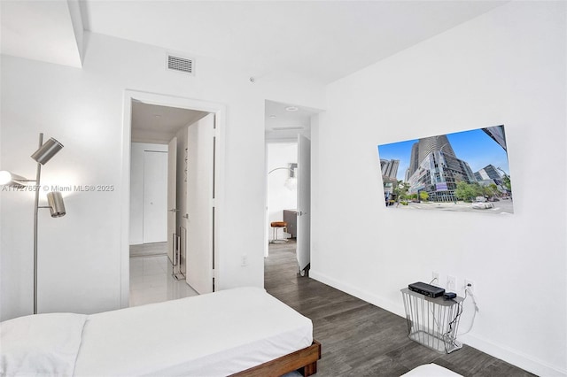 bedroom featuring dark hardwood / wood-style flooring and connected bathroom