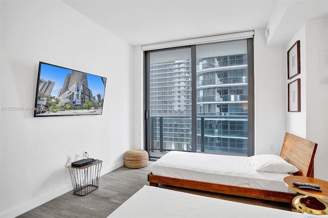 bedroom with hardwood / wood-style flooring, expansive windows, and multiple windows