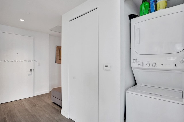 laundry room featuring wood-type flooring and stacked washer and clothes dryer