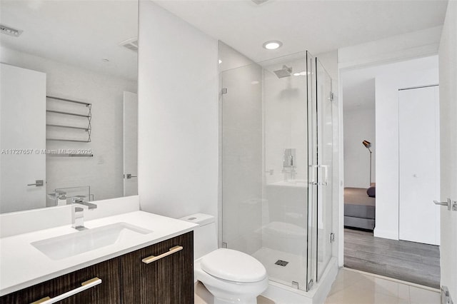 bathroom with a shower with door, toilet, and vanity