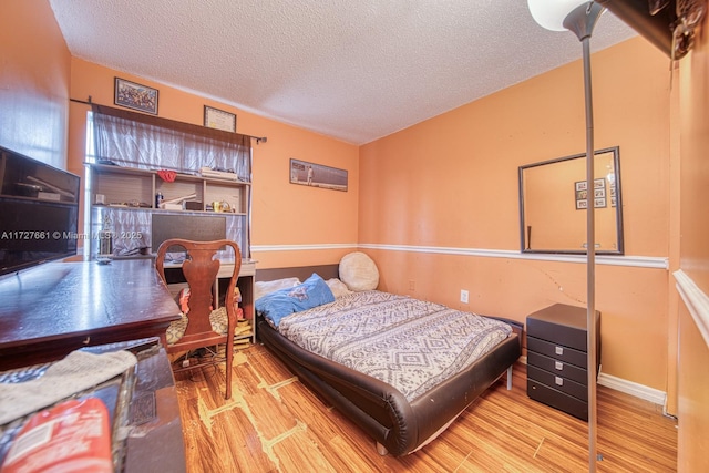 bedroom featuring light hardwood / wood-style floors and a textured ceiling