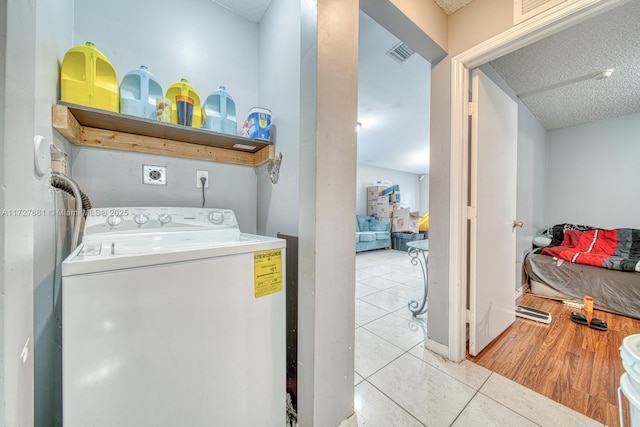 clothes washing area featuring washer / clothes dryer and light tile patterned flooring