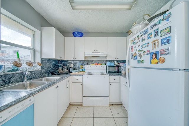 kitchen with sink, white appliances, white cabinets, light tile patterned flooring, and decorative backsplash