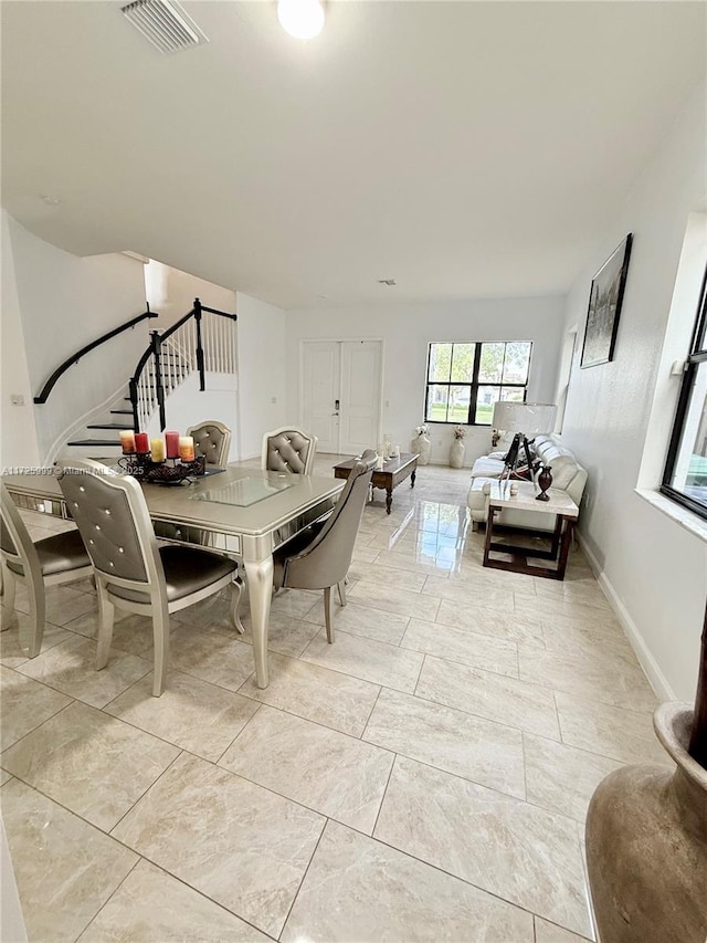 dining space with visible vents and stairs