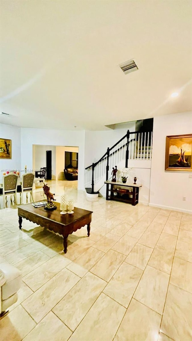 living area featuring visible vents and stairway