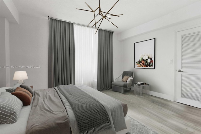 bedroom with a notable chandelier and light wood-type flooring