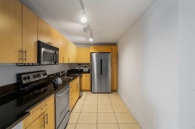 kitchen with light tile patterned floors, sink, appliances with stainless steel finishes, track lighting, and light brown cabinetry