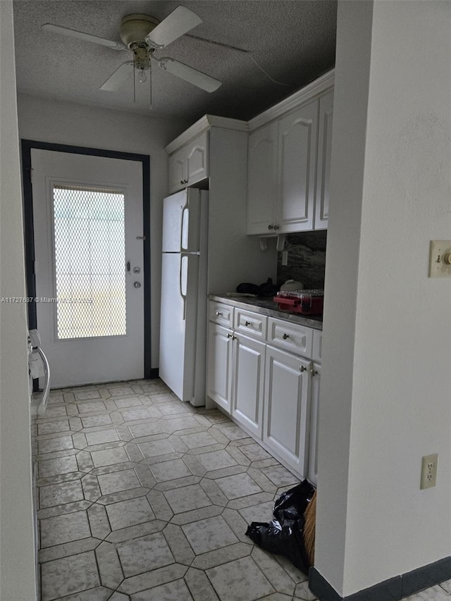 kitchen featuring ceiling fan, white cabinets, and white refrigerator