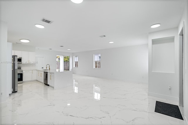 kitchen featuring sink, kitchen peninsula, white cabinets, and stainless steel appliances