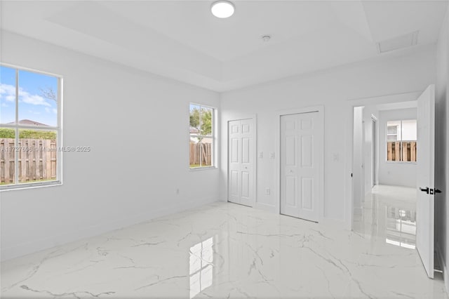 unfurnished bedroom featuring two closets and multiple windows