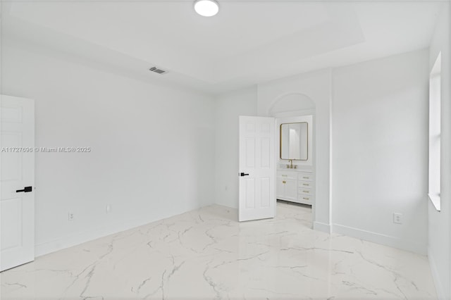 unfurnished bedroom featuring a raised ceiling