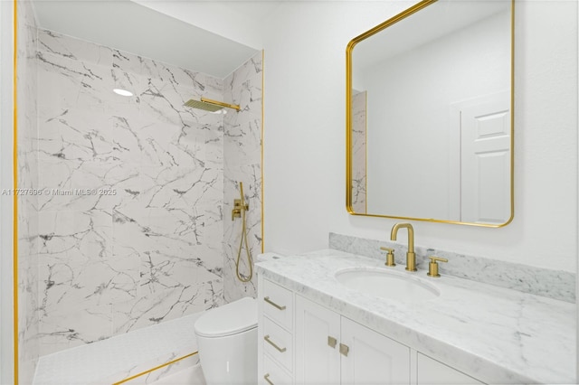 bathroom with toilet, vanity, and a tile shower