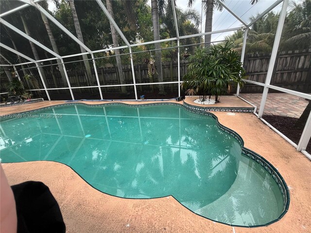 view of pool with a patio area and a lanai