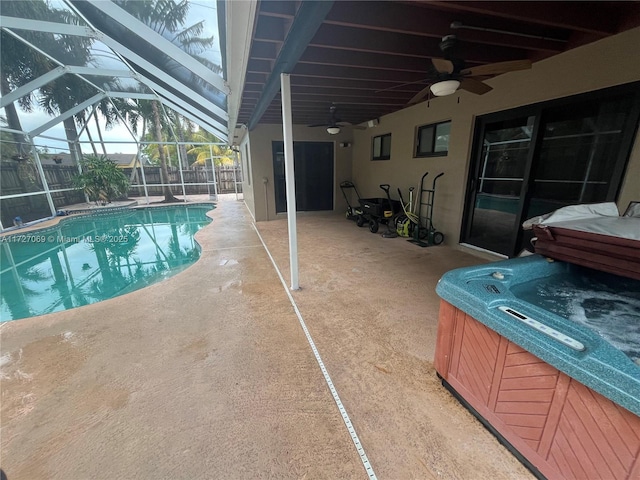 view of pool featuring a lanai, ceiling fan, a patio area, and a hot tub