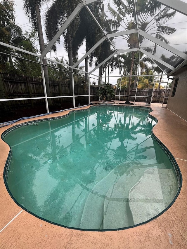 view of swimming pool with a patio and glass enclosure