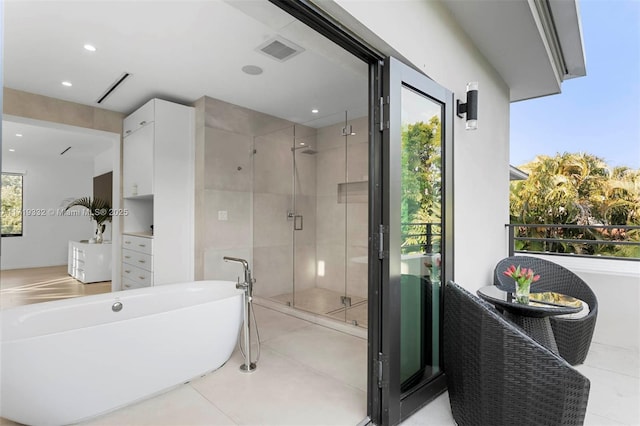 bathroom with separate shower and tub and tile patterned floors