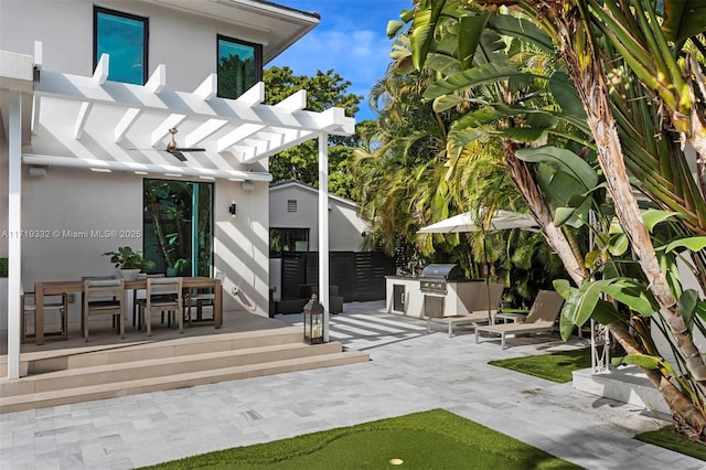 view of patio featuring exterior kitchen, a grill, and a pergola