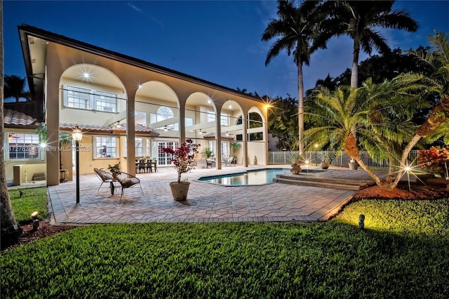 pool at twilight with a patio area