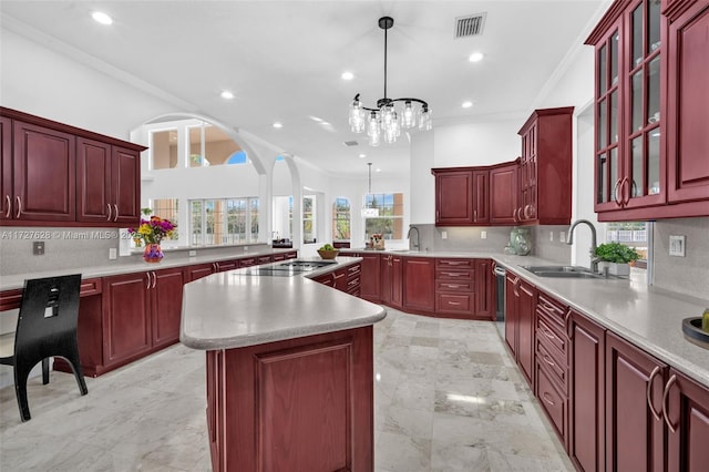 kitchen featuring tasteful backsplash, a notable chandelier, hanging light fixtures, crown molding, and a center island