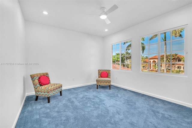 sitting room featuring ceiling fan, a wealth of natural light, and carpet flooring