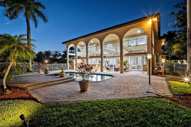 pool at dusk with a patio area