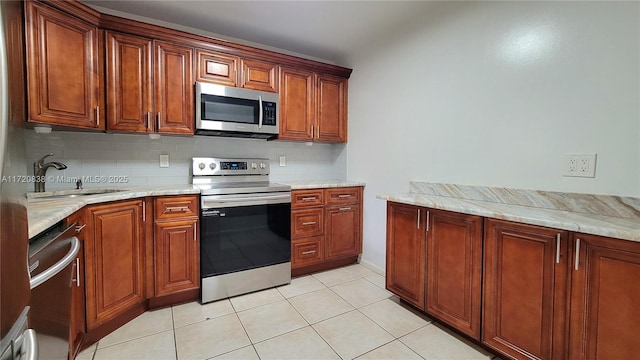 kitchen with tasteful backsplash, sink, light tile patterned flooring, appliances with stainless steel finishes, and light stone counters