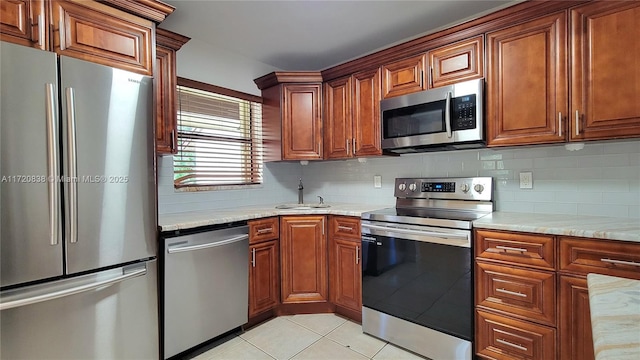 kitchen with light tile patterned floors, appliances with stainless steel finishes, backsplash, and sink