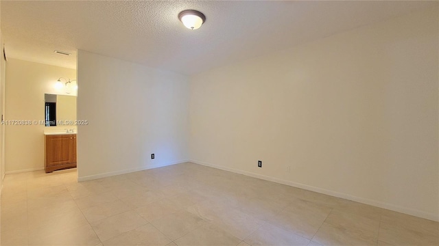 unfurnished room with a textured ceiling