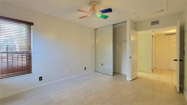 unfurnished bedroom featuring ceiling fan, light tile patterned flooring, and a closet