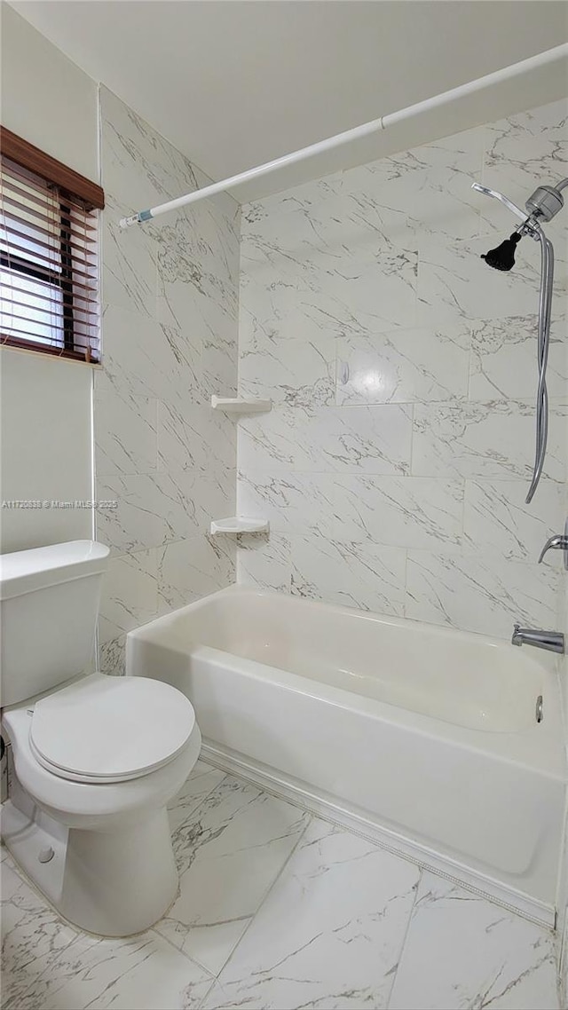 bathroom with toilet and tiled shower / bath