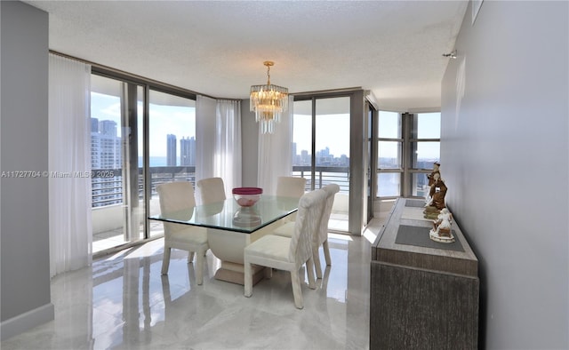 dining space featuring a water view, an inviting chandelier, floor to ceiling windows, and a textured ceiling