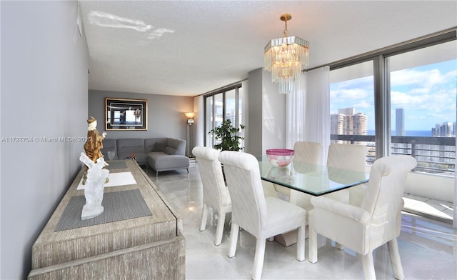 dining area with expansive windows, plenty of natural light, a chandelier, and a textured ceiling