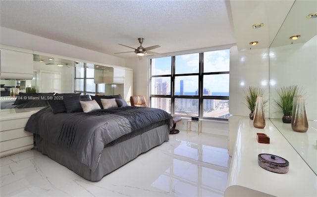 bedroom featuring ceiling fan, multiple windows, and a textured ceiling