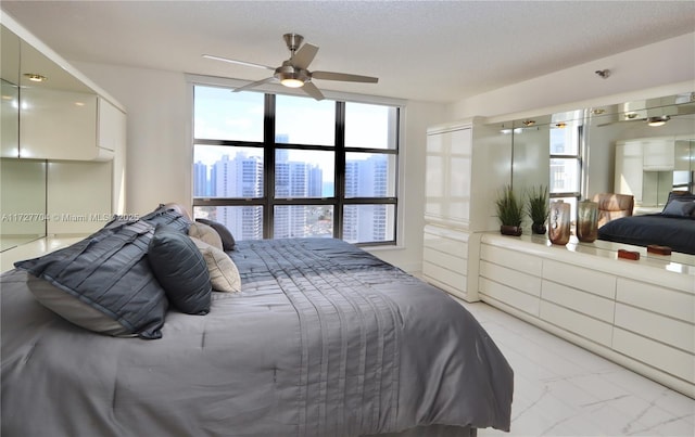 bedroom featuring ceiling fan and a textured ceiling