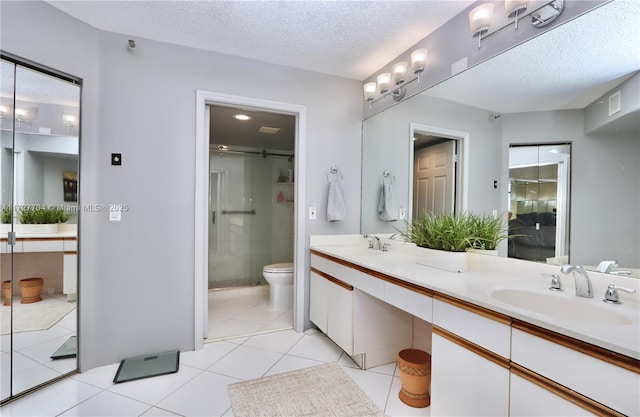 bathroom with toilet, tile patterned flooring, a textured ceiling, and vanity