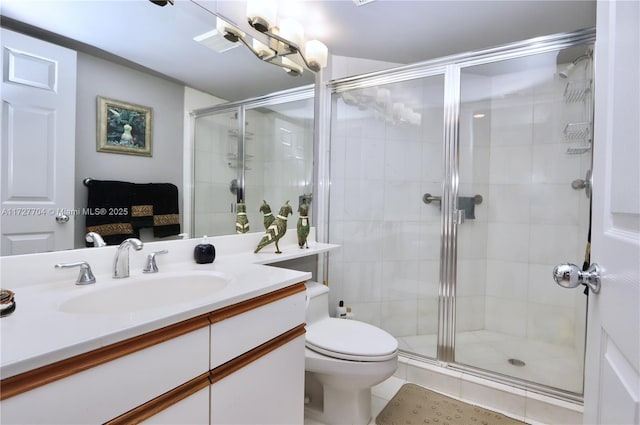 bathroom with a shower with shower door, vanity, and toilet