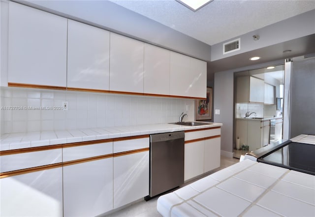 kitchen featuring tile counters, white cabinetry, backsplash, and stainless steel appliances