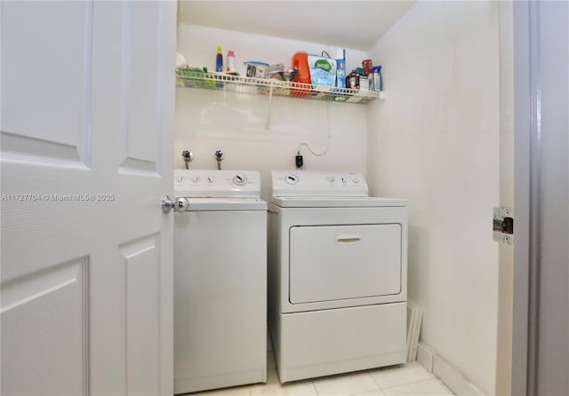 clothes washing area with washing machine and dryer and light tile patterned floors