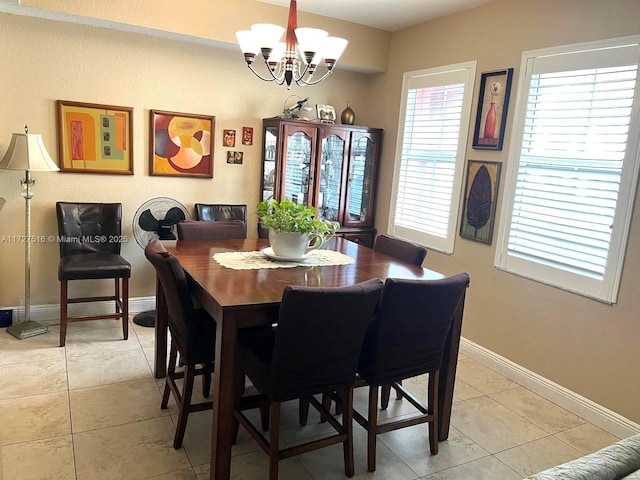 dining room featuring light tile patterned flooring and an inviting chandelier