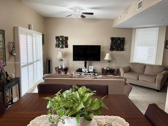 tiled living room with a textured ceiling and ceiling fan